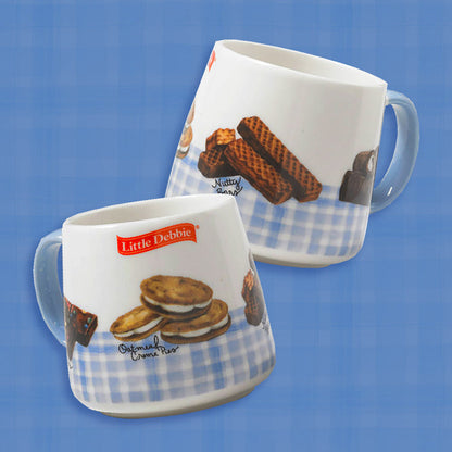 A Little Debbie gingham mug featuring a charming snack-themed design. Each white mug is accented with a light blue gingham border near the bottom and a matching light blue handle. The design showcases illustrations of Little Debbie snacks, including Oatmeal Creme Pies, Nutty Buddy Bars, Cosmic Brownies, and Swiss Rolls, with their names written in cursive. The red Little Debbie logo is prominently displayed near the top of the mug.